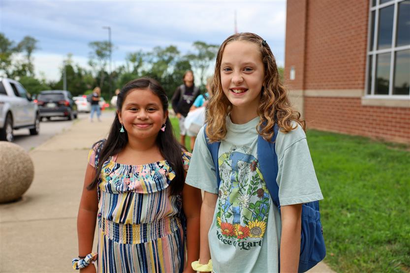 Two students smile